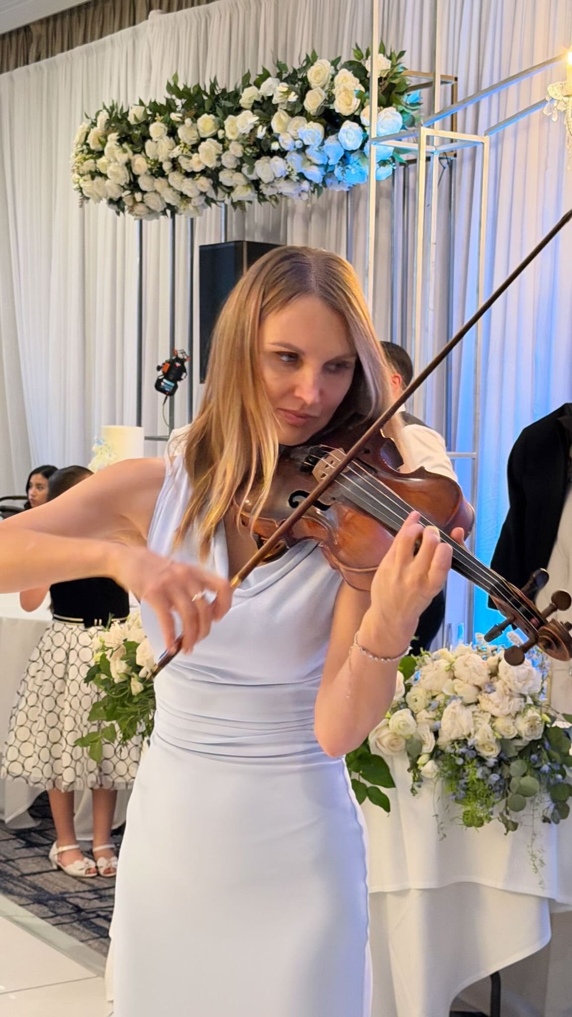 Mila performing violin at a wedding ceremony