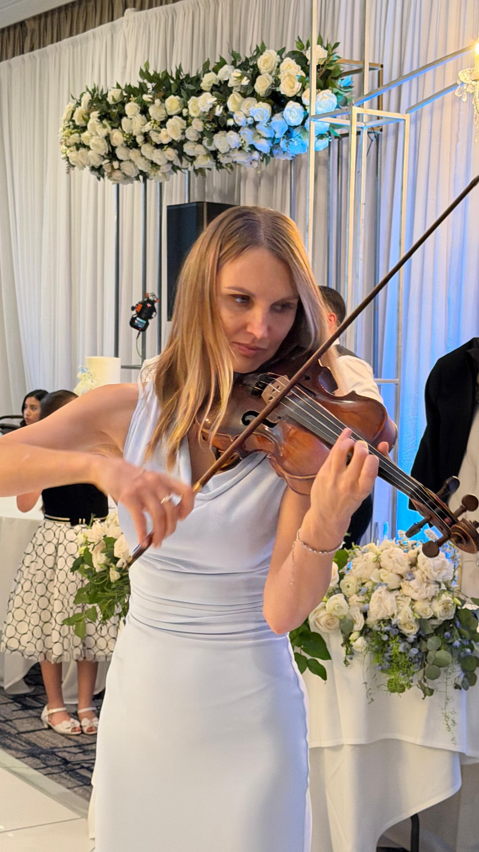 Mila playing solo violin at an event